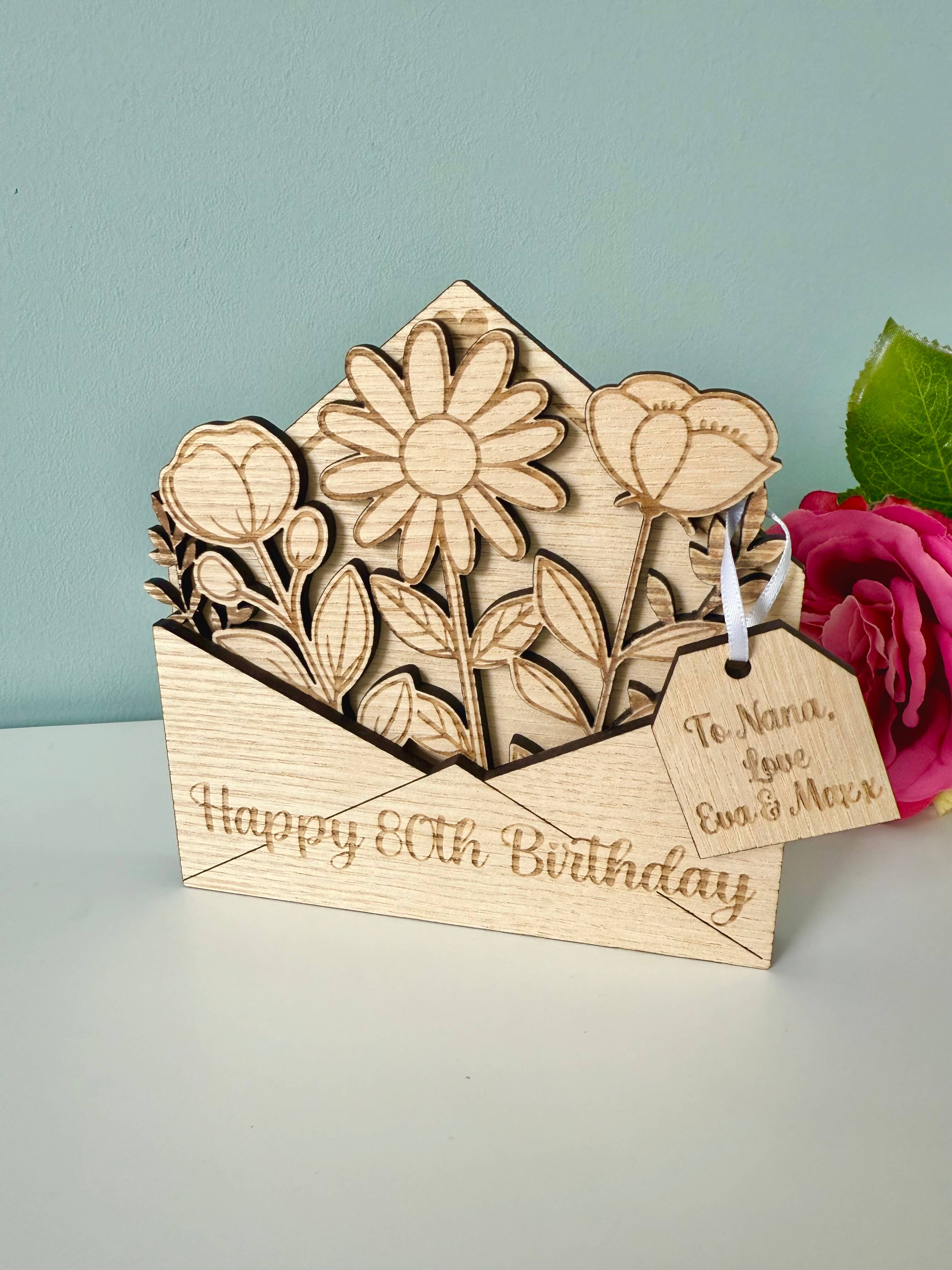 Wooden birthday card with floral design and pink rose on a light gray background
